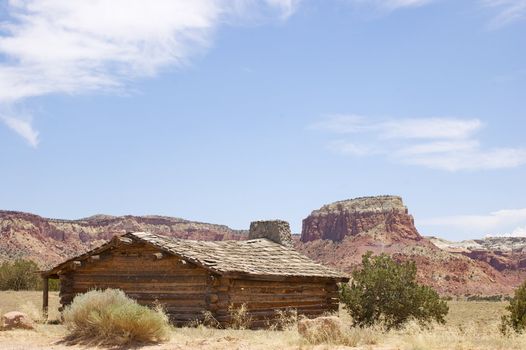 Rustic 'wild west' style log cabin against mountains, a blue sky and desert with copy space.





Rustic 'wild west' style log cabin against a blue sky with copy space.