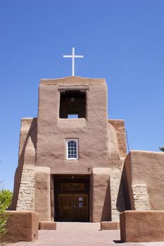 New Mexican Adobe Church in Santa Fe, against a blue sky with copy space.