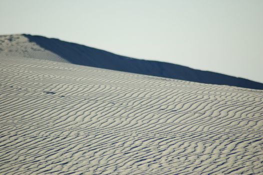 White Sands National Monument at sunset, featuring hills and dunes against the horizon, New Mexico