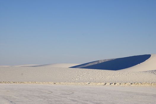 White Sands National Monument at sunset, featuring hills and dunes against the horizon, New Mexico