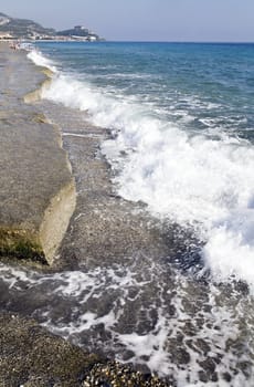 coast from pebble and blue foamy sea waves