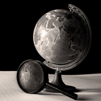 earth globe and magnifier in dark