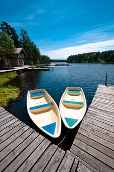 Two empty boats floating near wooden pier in camp