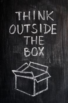 Concept of "Think Outside the box" drawn with chalk on a smudged blackboard 
