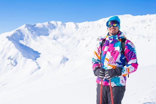 Young man with skis and a ski outfit in the Zillertal Arena, Austria