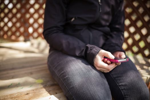 woman reading on her smart phone in a treehouse