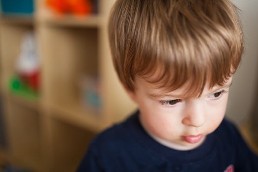 Sad little boy inside a house