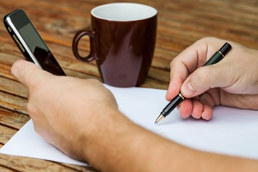 Blank white paper with pen and a mobile phone.