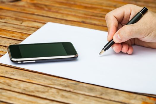 Blank white paper with pen and a mobile phone.