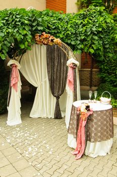 Outdoor wedding arch with table under grapevine