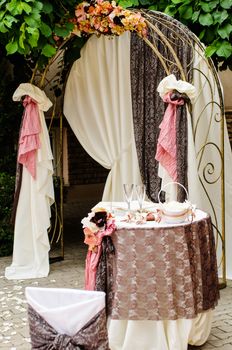 Outdoor wedding arch with table under grapevine