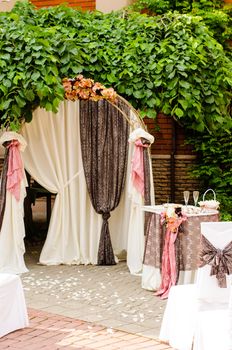 Outdoor wedding arch with table under grapevine