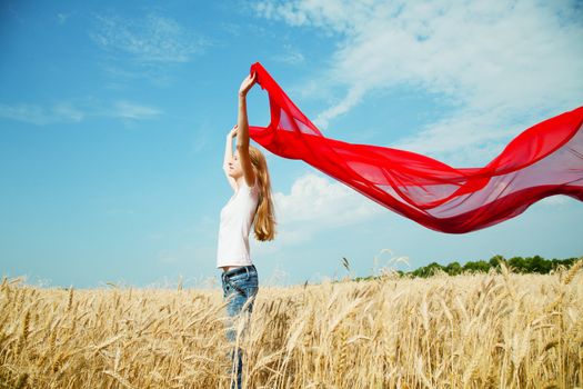 Teen girl at a wheat field with red fabric