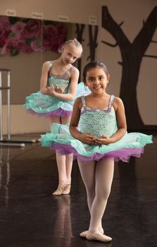 Two young ballet dresses rehearsing in a dance studio
