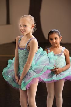 Shy little girls in ballet dresses at a dance studio