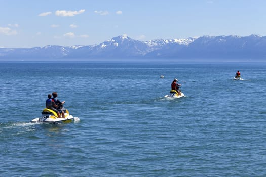 Riders on motoscooters on lake Tahoe, CA.