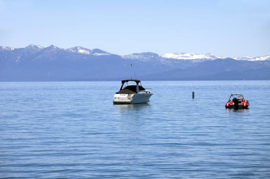 Power boats on lake tahoe with surrounding mountains.