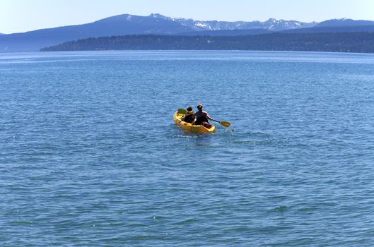 Yellow canoe woman with son on lake Tahoe, CA.