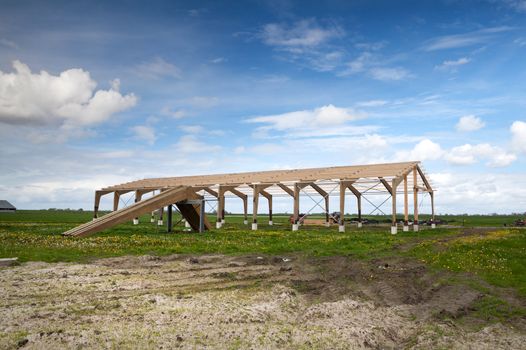 construction of a wooden house in the middle of the field