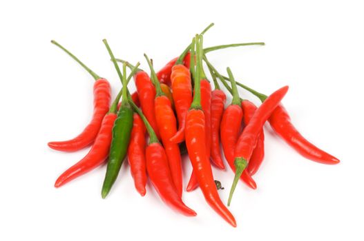 Arrangement of one green and heap red chili peppers isolated in white background