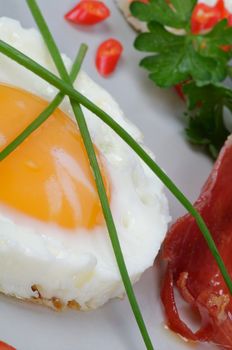 Fried Eggs Sunny Side Up with Lettuce and bacon closeup on gray plate