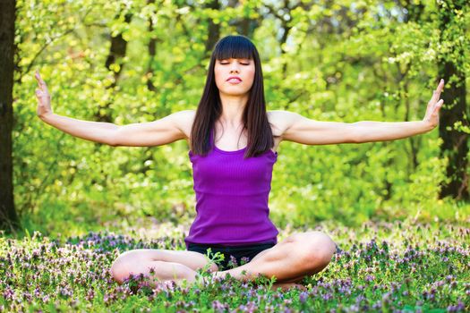 Young woman doing meditation outdoor in forest