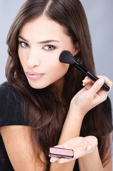 young pretty girl doing make up with powder brush
