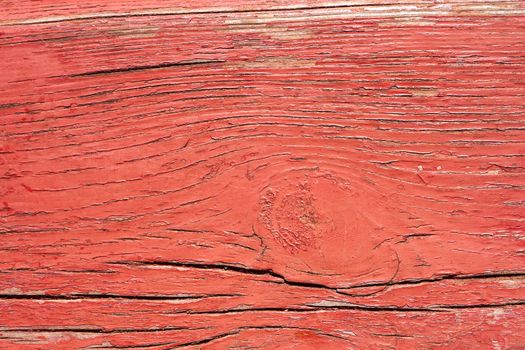 Detail of old wooden boards painted in red with several layers of shelled paint