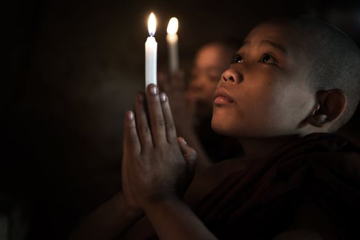 Little monks praying with candlelight