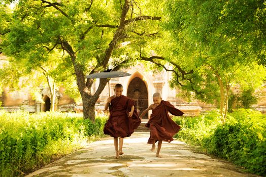 Two little monks running outdoors