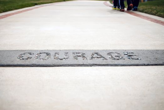 courage text on the concrete walk