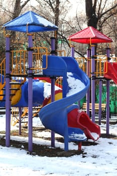 Colorful slides in the park under the snow