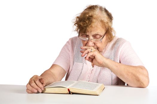 The old woman in points thoughtfully looks in the book on a white background