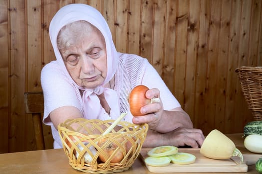 The old woman hold onions t a table