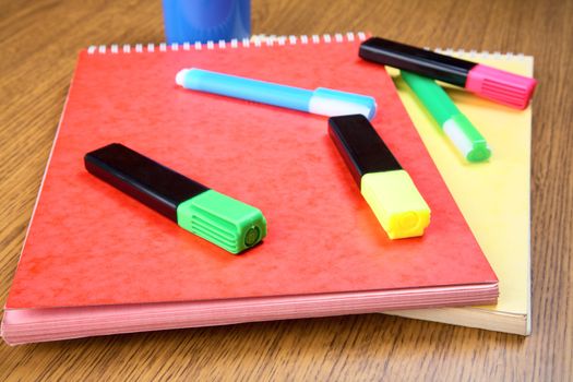 Markers and notebooks on a desk