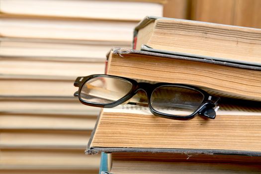 Pile of books and old glasses close up