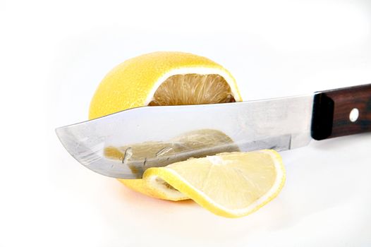 Knife a cutting juicy lemon on a white background