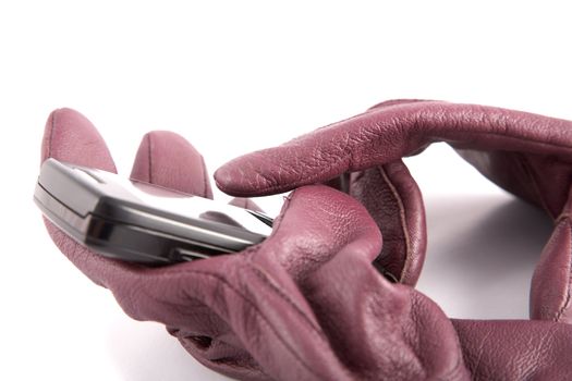 Leather gloves compress cellular telephone on a white background
