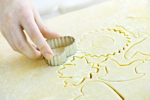 Cutting cookie shapes in rolled dough with cutter