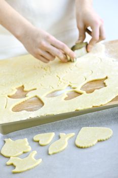 Woman using cookie cutter and baking homemade cookies