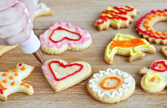Decorating homemade shortbread cookies with icing from piping bag
