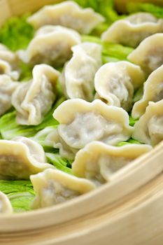 Closeup of bamboo steamer with cooked dumplings