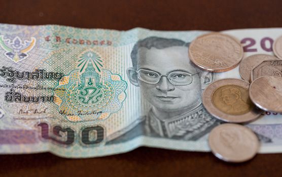 Twenty baht note from Thailand with miscellaneous coins