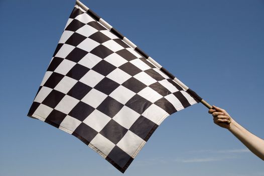 Auto racing checkered flag on a background of the  blue sky.