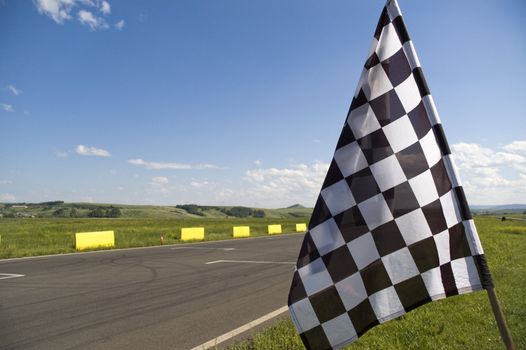 Auto racing checkered flag on a background of the  blue sky.