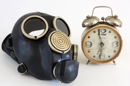 The Gas mask and old watch on white background.