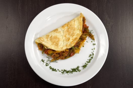 Pancakes with vegetables on a white plate.