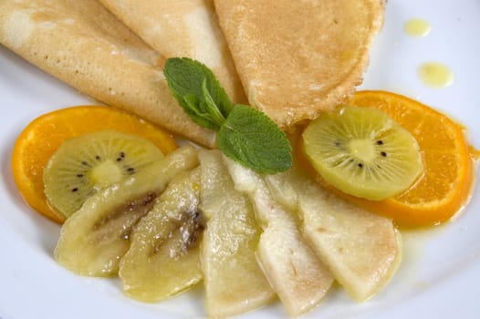 Pancakes with fruit on a white plate.