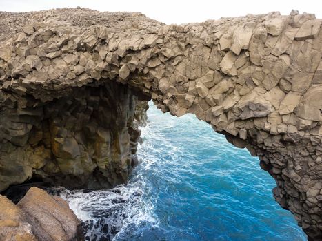 Scenic view of basalt bridge formation over sea on coastline of Iceland.