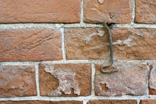 Brick wall and old metal hook.